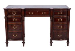 An Edwardian mahogany kneehole desk of shaped and serpentine fronted outline,