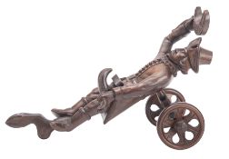 A carved and stained walnut figural bottle coaster,