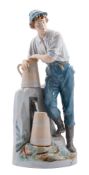 A Royal Dux Bohemia porcelain figure of a young lad filling pitchers at a water pump,
