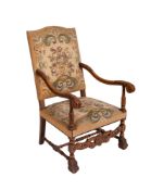 A carved beech wood open arm chair in the Carolean taste,