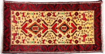 A Belouchistan rug, the ivory field with twin stepped medallions and stylised designs and animals,
