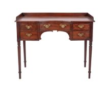 An early 19th century mahogany side or dressing table, with a reeded three-quarter ledge back,