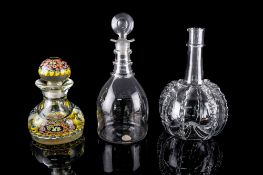A clear glass decanter of mallet shaped form with triple neck rings and bullseye stopper, 27cm high,