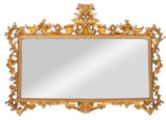 A carved giltwood landscape wall mirror with acanthus scroll cresting and surround,