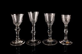 Four English wine glasses each with faceted knopped stems and conical foot,