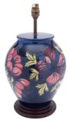 A John Moorcroft pottery lamp tube lined in the Anemone pattern reserved on a blue ground,