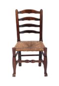 An 18th Century ash and elm ladderback dining chair, having a rush seat, on turned underframing,