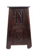 An unusual oak linen cupboard, 17th century; the overhanging rectangular top above two panel doors,