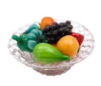 A clear glass lattice basket containing a selection of coloured glass trompe l'oeil fruits,
