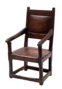 An oak wainscot chair; late 17th century; with panel backrest and tapered arms above a panel seat;