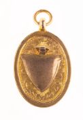A 9ct gold Art Deco commemorative shield pendant, of oval form,