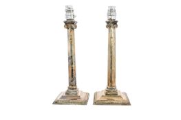 A pair of George III silver candlesticks, in the form of Corinthian columns, with gadrooned borders,