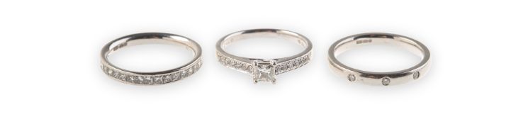 A set of three platinum and diamond rings of varied design, including a platinum ring,