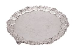 An Edwardian small silver salver/ waiter, of shaped circular outline, with a foliate shell border,
