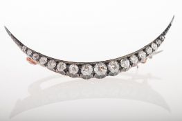 A Victorian diamond crescent moon brooch, pie-crust and grain set with graduated old-cut diamonds,