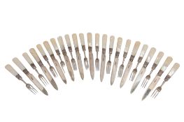 An Edwardian set of twelve silver dessert forks and eleven matching knives, with engraved blades,