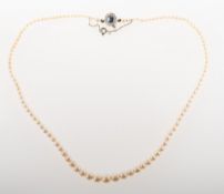 A pearl necklace with a sapphire and diamond clasp, a string of graduated cultured pearls,