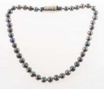 A black freshwater pearl necklace, the pearls of baroque shape, some with peacock overtones,