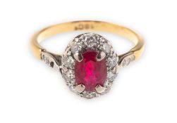 A ruby and diamond cluster ring, claw set to the centre with an oval-cut ruby,