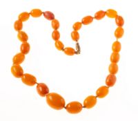 An amber necklace, a graduated row of knotted oval amber beads, screw clasp, length approx. 48.