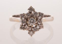 A diamond starburst cluster ring, claw set with an array of brilliant-cut diamonds,