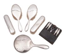 A George V eleven-piece silver dressing set, comprising of two hair brushes, two clothes brushes,