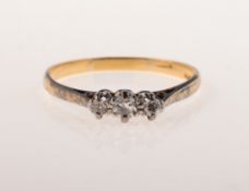 A three stone diamond ring, claw set with three single-cut diamonds,
