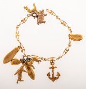 An antique charm bracelet with nine charms, the openwork bracelet of three leaf clover design,