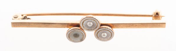 A mother of pearl, enamel and seed pearl brooch, a bar set to the centre with a trio of circles,