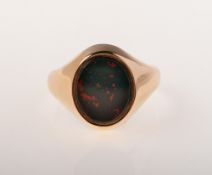 A 9ct gold bloodstone signet ring, set with an oval plaque of bloodstone, UK hallmark,