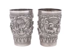 A very near pair* of late 19th/ early 20th century Burmese silver beakers, tapering circular form,