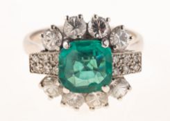 A 1980's emerald and diamond cluster ring, claw set to the centre with a square-cut emerald,