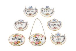 A set of five Crown Staffordshire porcelain wine labels,