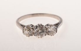 A three stone diamond ring, claw set with three old-cut diamonds, (slightly off round),