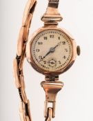A 1930s 9K gold wristwatch the round cream dial having black Arabic numerals,