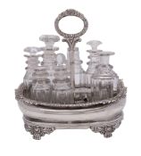 A George IV boat-shaped silver cruet frame, with a decorative border and central handle,