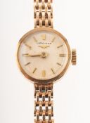 Longines a lady's 9K gold wristwatch the round cream dial having raised gold baton numerals,