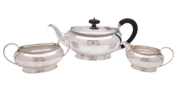A George V three-piece silver tea set, of squat oval form, with fluted borders,