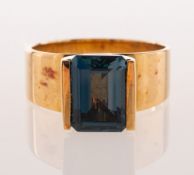 A 9ct gold London blue topaz dress ring, tension set with a rectangular-cut London blue topaz,