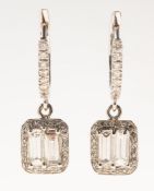 A pair of diamond drop earrings, each with a 'huggie' hoop style fitting,