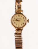 A 9K gold wristwatch the round cream dial having raised gold Arabic numerals,