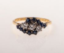 A diamond and sapphire ring, claw set on a twist to the centre with three brilliant-cut diamond,
