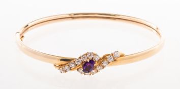 A 9ct gold bangle, with a twist design to the front section,