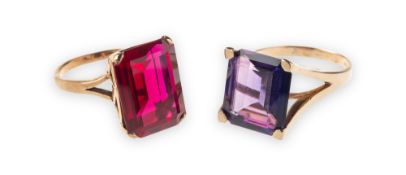 Two cocktail rings of varied design, including a ring claw set with a rectangular-cut red stone,