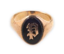 A signet ring, with a central black plaque with a monogrammed overlay, replacement shank,