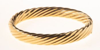 A 9ct gold twist designed hinged bangle, UK import mark 375, inner length approx. 6.