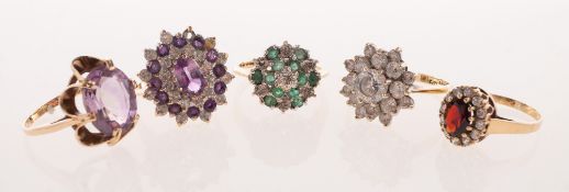 Five 9ct gold dress rings of varied design, including an emerald and diamond cluster ring,