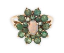 An emerald and opal cluster ring, claw set to the centre with an oval opal cabochon,