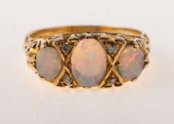 A 1970's 18ct gold opal and diamond ring, set with three oval opal cabochons,