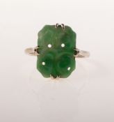 A jade ring, claw set with a rectangular carved and pierced plaque of jade, white metal, marked 9ct,